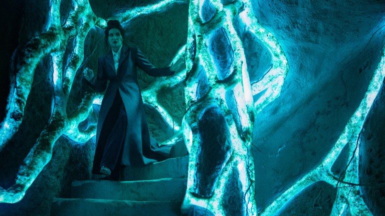 Agatha Harkness (Kathryn Hahn) walks through the entrance to the Witches' Road in Agatha All Along.