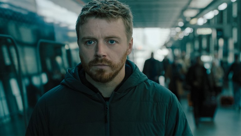 Jack Lowden as River Cartwright walking through a train station in Slow Horses season 4